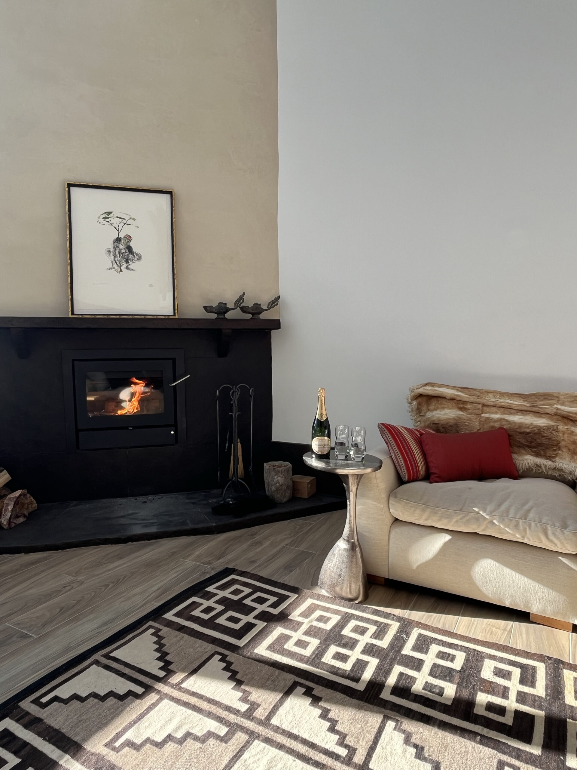 a beautiful livingroom with fireplace, art, rug and couch